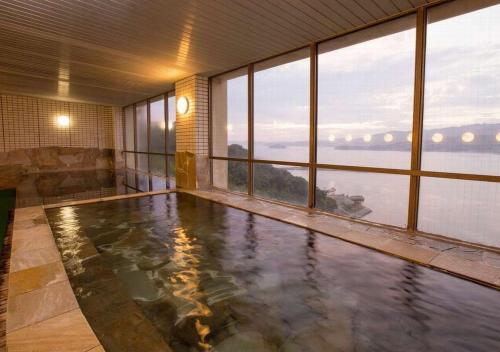 una grande piscina in una stanza con finestre di Wano Resort Hazu a Gamagōri
