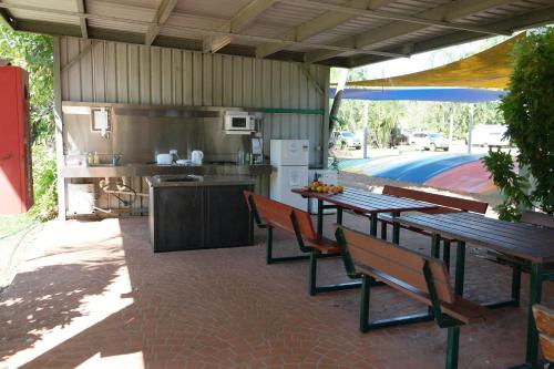 patio con mesa y sillas y cocina en BIG4 Howard Springs Holiday Park, en Darwin