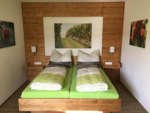 - une chambre avec un lit vert orné d'une peinture murale dans l'établissement Gustoplatzl, à Klöch