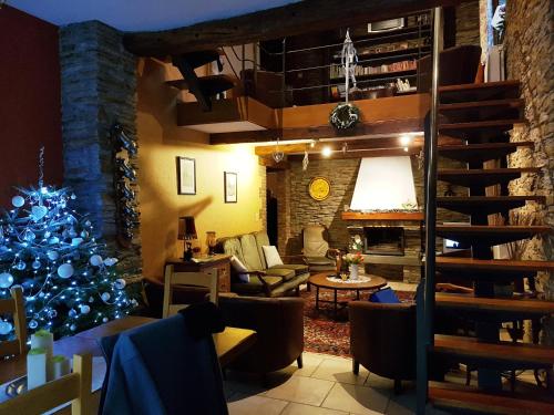 a living room with a christmas tree and a staircase at La Grange in Rochehaut