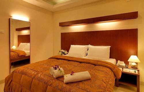 a hotel room with a large bed with two towels on it at Dhanunjayas Luxury Hotel in Hosūr