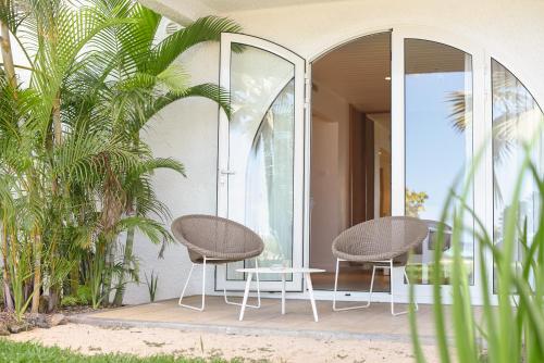 two chairs and a table on a patio with mirrors at Canonnier Beachcomber Golf Resort & Spa in Pointe aux Cannoniers