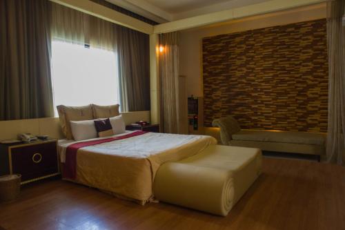 a hotel room with a large bed and a chair at Lu Kang Villa Spa in Lugang