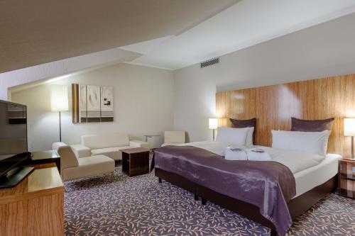 Mercure Hotel Wiesbaden City tesisinde bir odada yatak veya yataklar
