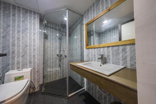een badkamer met een wastafel en een douche bij Golden Daisy Hotel in Phu Quoc