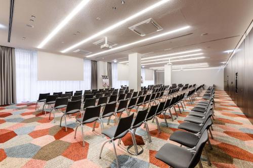 an empty room with rows of chairs in it at Mercure Hotel Wiesbaden City in Wiesbaden