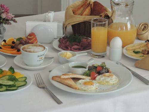 un tavolo sormontato da piatti di cibi e bevande per la colazione di Hotel Monaco a Astana