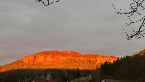 a mountain with the sun shining on it at Chalupa Pod Drábskými světničkami in Mnichovo Hradiště
