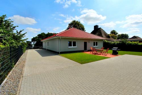 a small white house with a red roof at VILLA SEE_RESIDENZ in Malchow