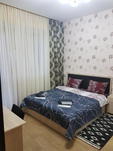 a bedroom with a bed with a blue comforter at Nova city center apartments in Tbilisi City