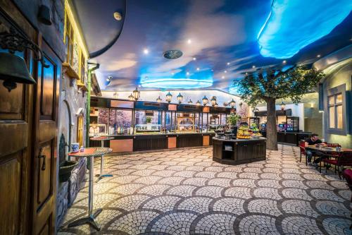 a restaurant with a bar with blue lights on the ceiling at King's Resort - casino and hotels in Rozvadov