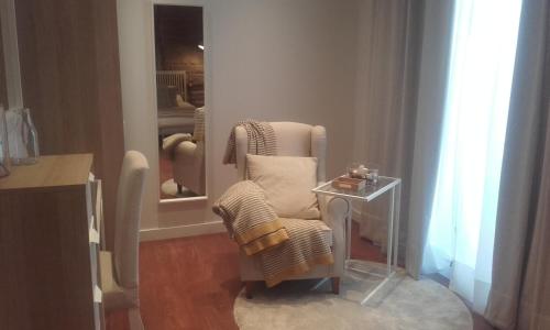 a white chair and a table in a room at Casa de Mi Abuela Ribera del Duero in Roa