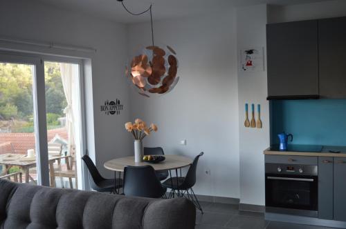 a living room with a table and a kitchen with a window at Summer House Krištof in Vrbanj