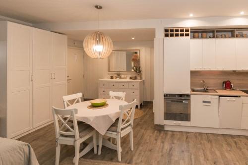 a kitchen and dining room with a table and chairs at Marių pelėdos in Preila