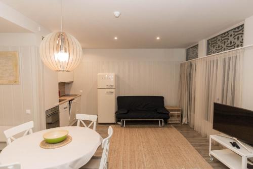 a kitchen and living room with a white table and chairs at Marių pelėdos in Preila