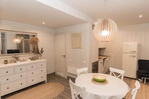 a kitchen and dining room with a white table and chairs at Marių pelėdos in Preila