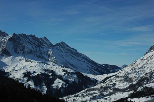 a snow covered mountain range with snow on it at Hôtel Flor'Alpes in La Giettaz