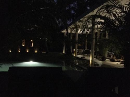 a night view of a pool with palm trees and a building at KAJU GREEN eco lodges in Unawatuna