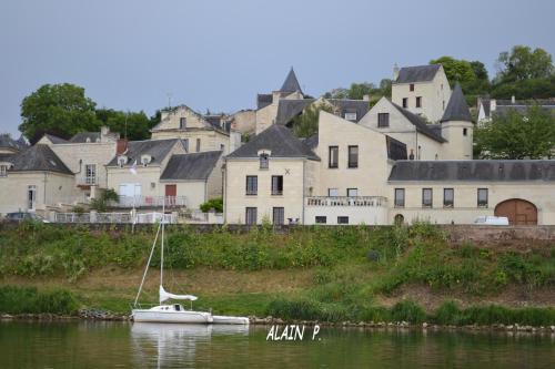 a white boat in the water in front of a city at le prieuré in Montsoreau