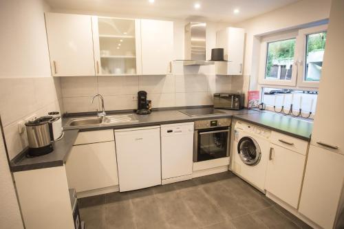 a white kitchen with a sink and a dishwasher at Downtown Apartments Center in Baden-Baden