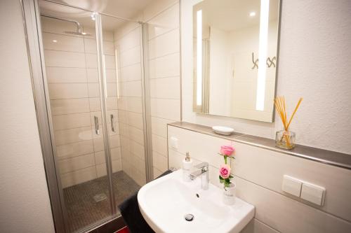 La salle de bains est pourvue d'un lavabo et d'une douche. dans l'établissement Downtown Apartments, à Baden-Baden
