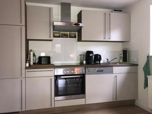 a kitchen with white cabinets and an oven at Fewo Am Leegen Berg in Xanten