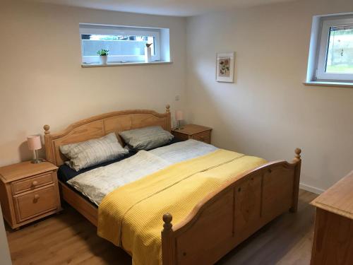 クサンテンにあるFewo Am Leegen Bergのベッドルーム1室(木製ベッド1台、黄色い毛布付)