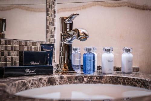 a bathroom sink with a faucet and bottles of soap at King's Resort - casino and hotels in Rozvadov