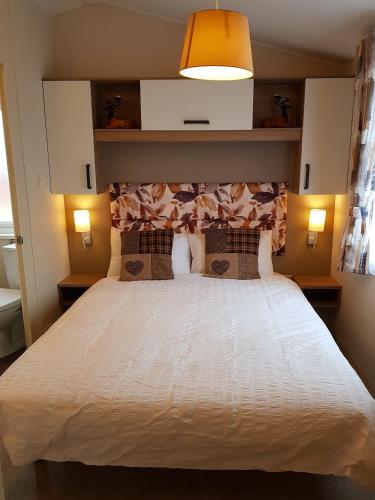 a bedroom with a large white bed with two pillows at Shanthi Lodge in Dunning