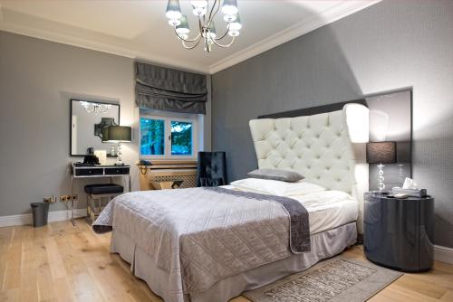 a bedroom with a large bed and a chandelier at Dwór na Wolicy in Dębica
