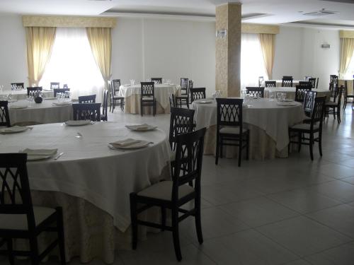 a dining room with white tables and chairs at Hotel The Queen in Pastorano