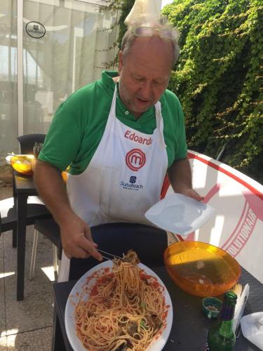 a man preparing a plate of spaghetti on a table at SUITEBEACH b&b and resort in Marsala