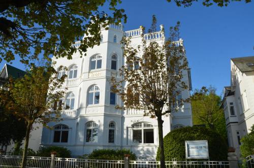 a white building with a tree in front of it at Villa Sirene - Wohnung 08 in Binz