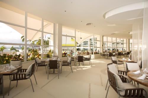a restaurant with tables and chairs and windows at The Hacienda at Krystal Grand Puerto Vallarta- All Inclusive in Puerto Vallarta