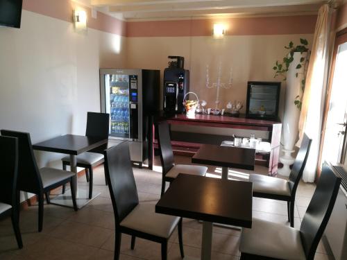 a restaurant with tables and chairs and a refrigerator at Sweet Home in Treviso