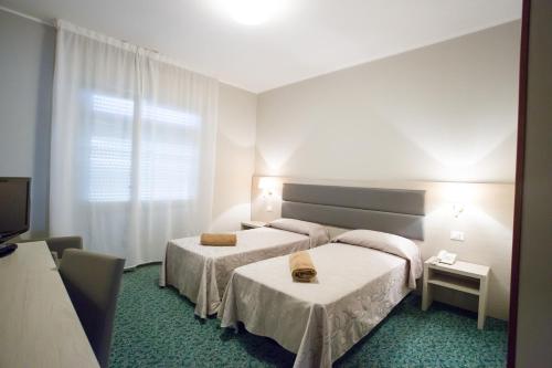 アーバノ・テルメにあるHotel Smeraldoのベッド2台とテレビが備わるホテルルームです。