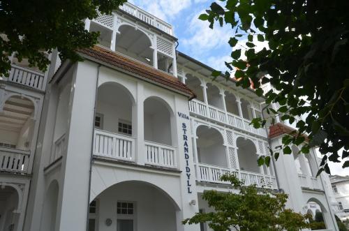 奧茨巴德賓茲的住宿－Villa Strandidyll Wohnung 9，白色的大建筑,设有白色的窗户和屋顶