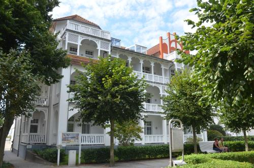 奧茨巴德賓茲的住宿－Villa Strandidyll Wohnung 9，前面有树木的白色建筑