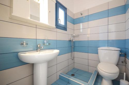 a blue and white bathroom with a toilet and a sink at Magic Summer in Agia Anna Naxos