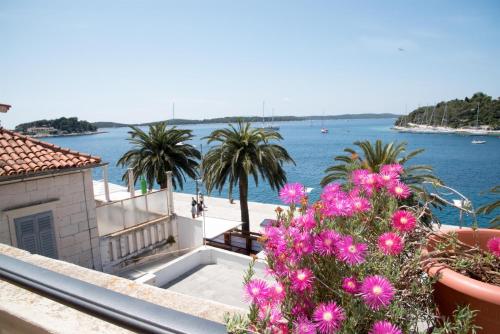 a view of the water from a balcony with flowers at Holiday Home Meditation in Hvar