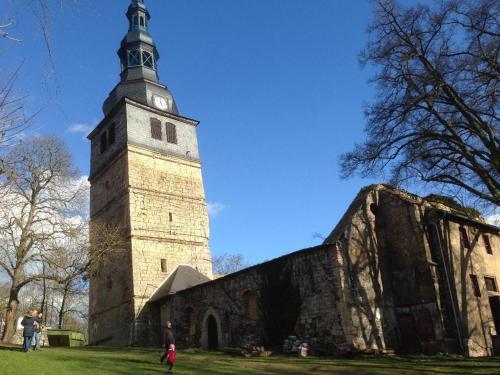 a church with a tower with a clock on it at Ratstraße im Kyffhäuser - krumm & schief in Bad Frankenhausen