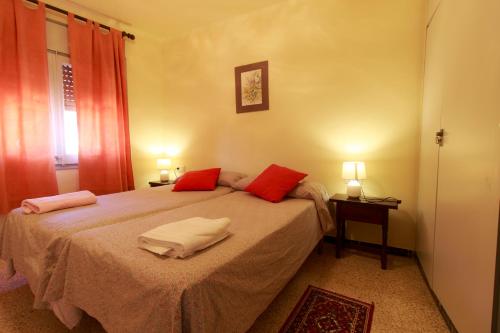 a bedroom with a bed with red pillows on it at Ca La Conxita Hostal & Restaurante in La Vajol