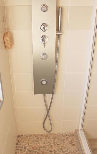 a shower with a hose in a bathroom at Casa Esti in Olhão