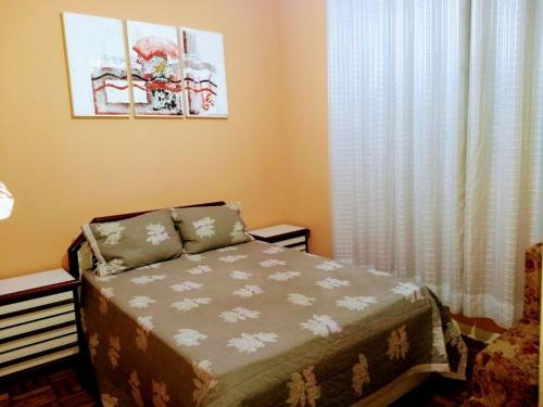een kleine slaapkamer met een bed en een raam bij Apartamento Canto do Forte 200m da Praia in Praia Grande