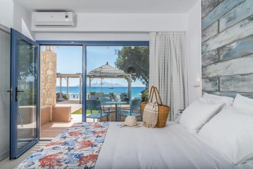 a bedroom with a bed and a view of the ocean at Kordistos Hotel in Kefalos