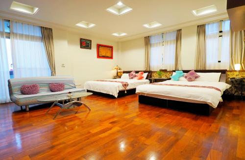a large room with two beds and a couch at Nature House Homestay in Dongshan