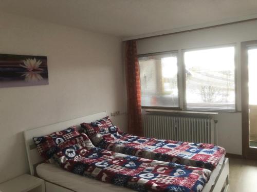 um quarto com uma cama com um cobertor em Chiemgau Apartments II (Schuhbaum) em Inzell