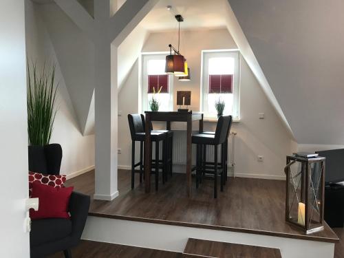 a dining room and living room with a table and chairs at Quartier 1903 in Oldenburg