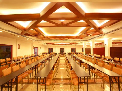 an empty lecture hall with rows of tables and chairs at Hotel Devaragam by K P Namboodiri's in Guruvāyūr