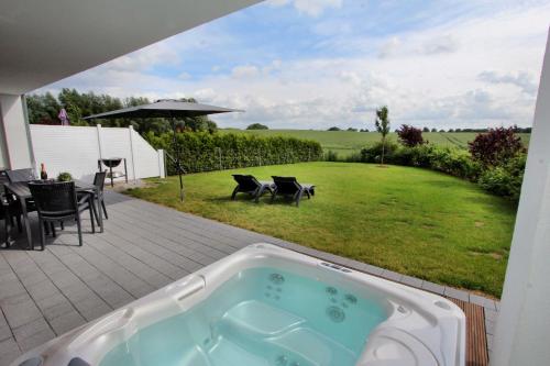 bañera de hidromasaje en un patio con patio en Villa Grande Fewo Enjoy We 2, en Göhren-Lebbin